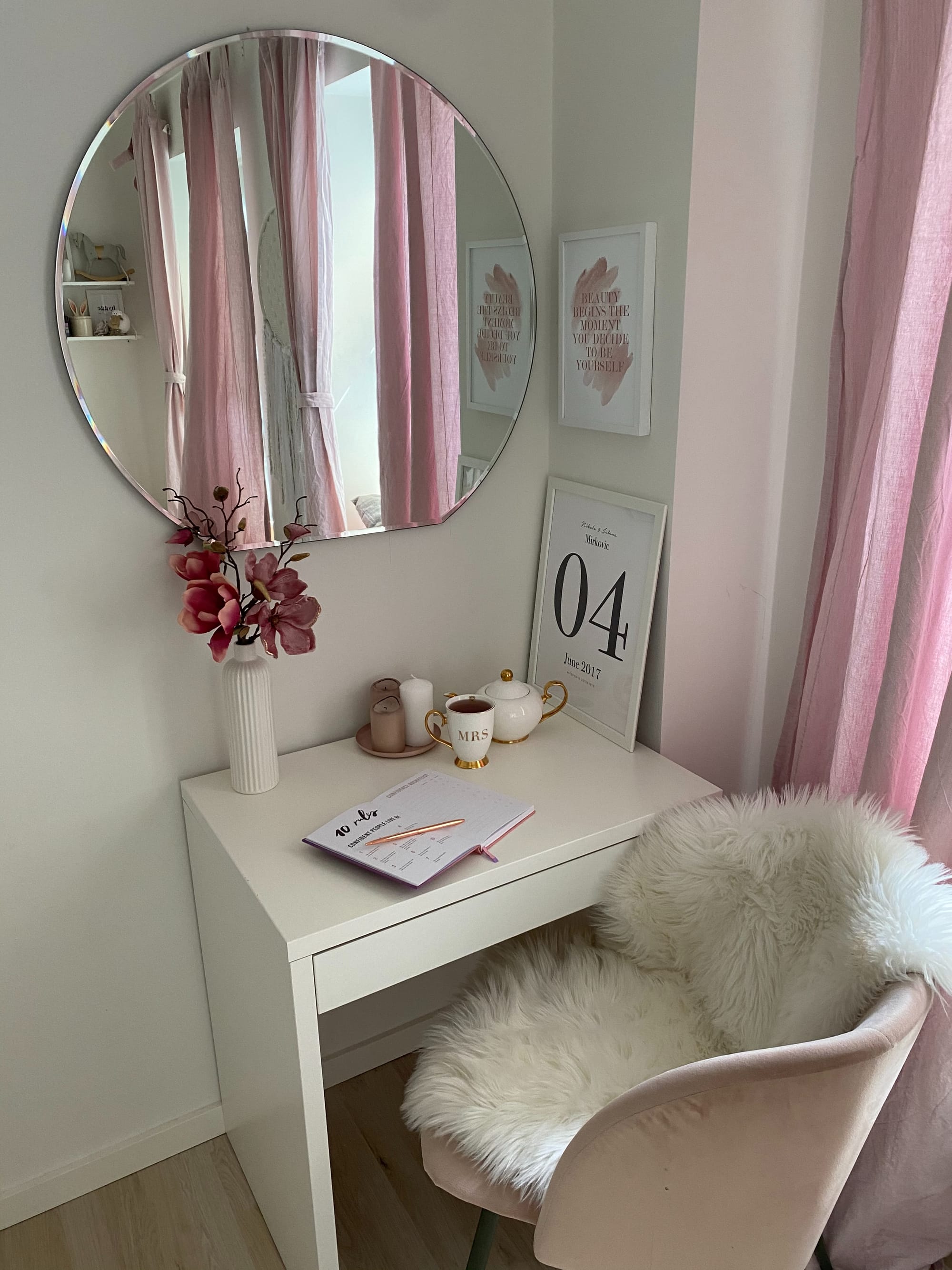 A white fluffy blanket in a chair and pink furniture