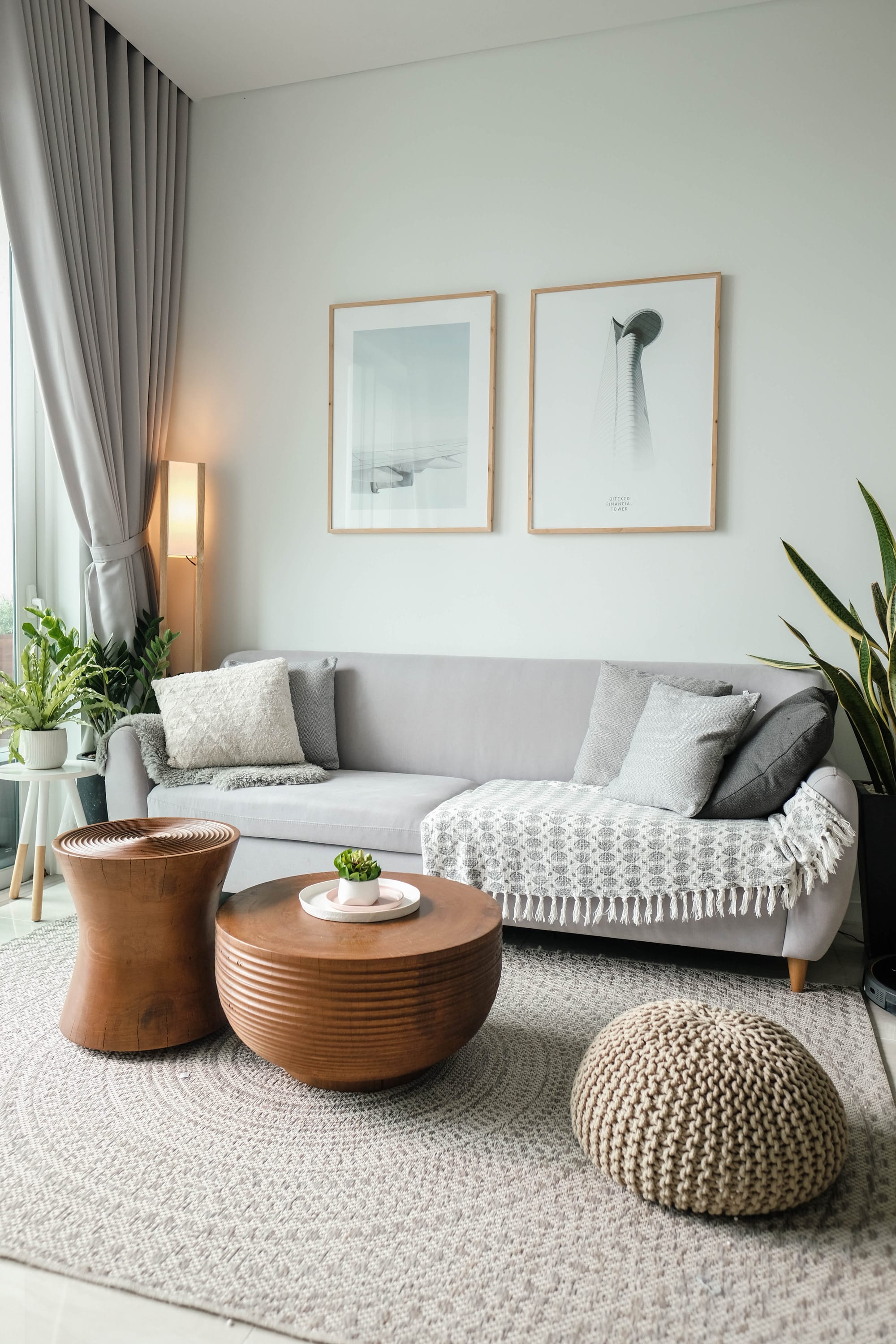 A grey couch with throw pillows and an ottoman