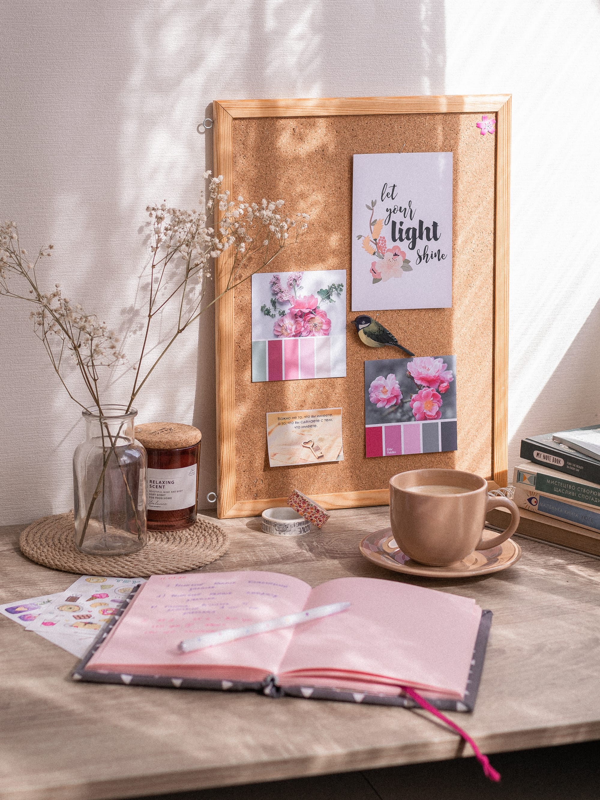 A corkboard and journal on a desk