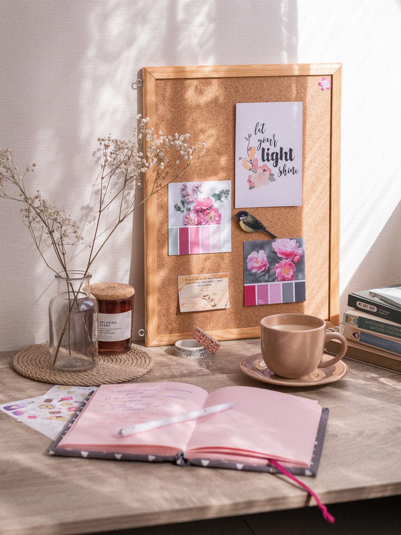 baddie bedroom ideas with a pink journal, wall art, pin board, candle and desk
